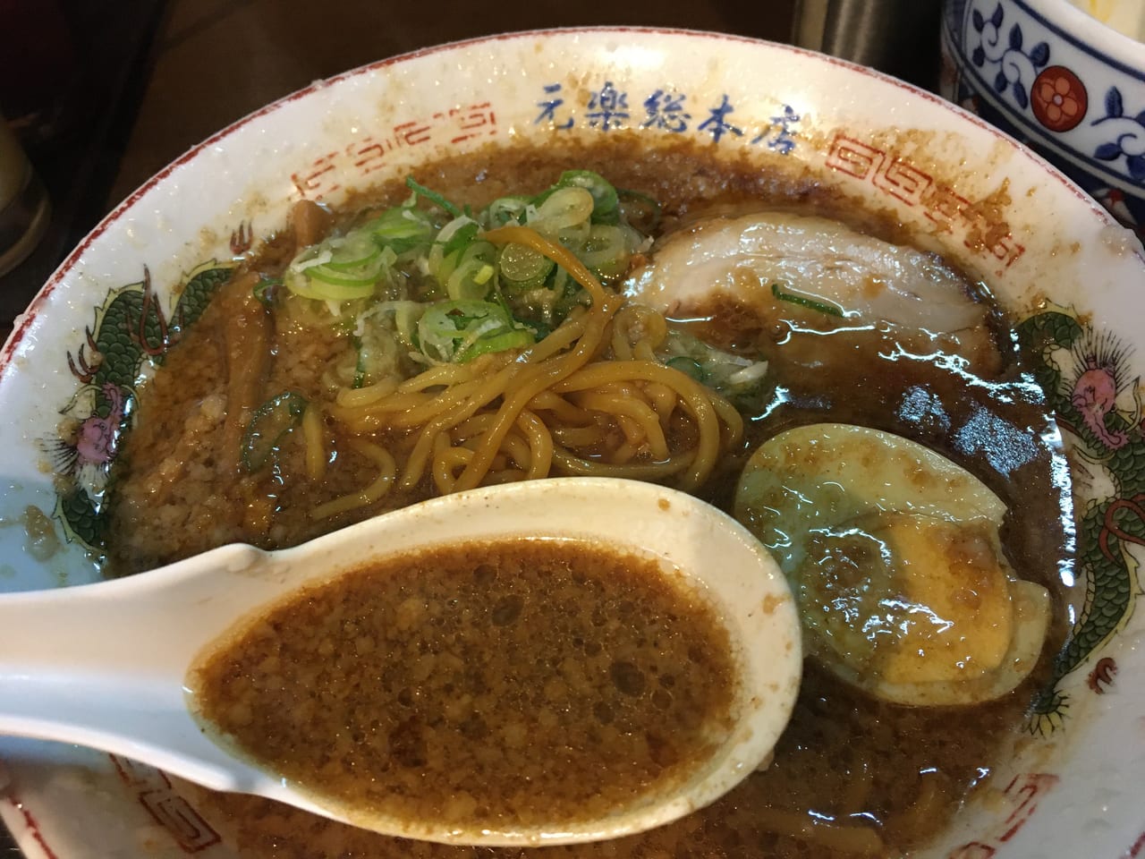 レンゲですくった背脂が強調されたラーメンの丼